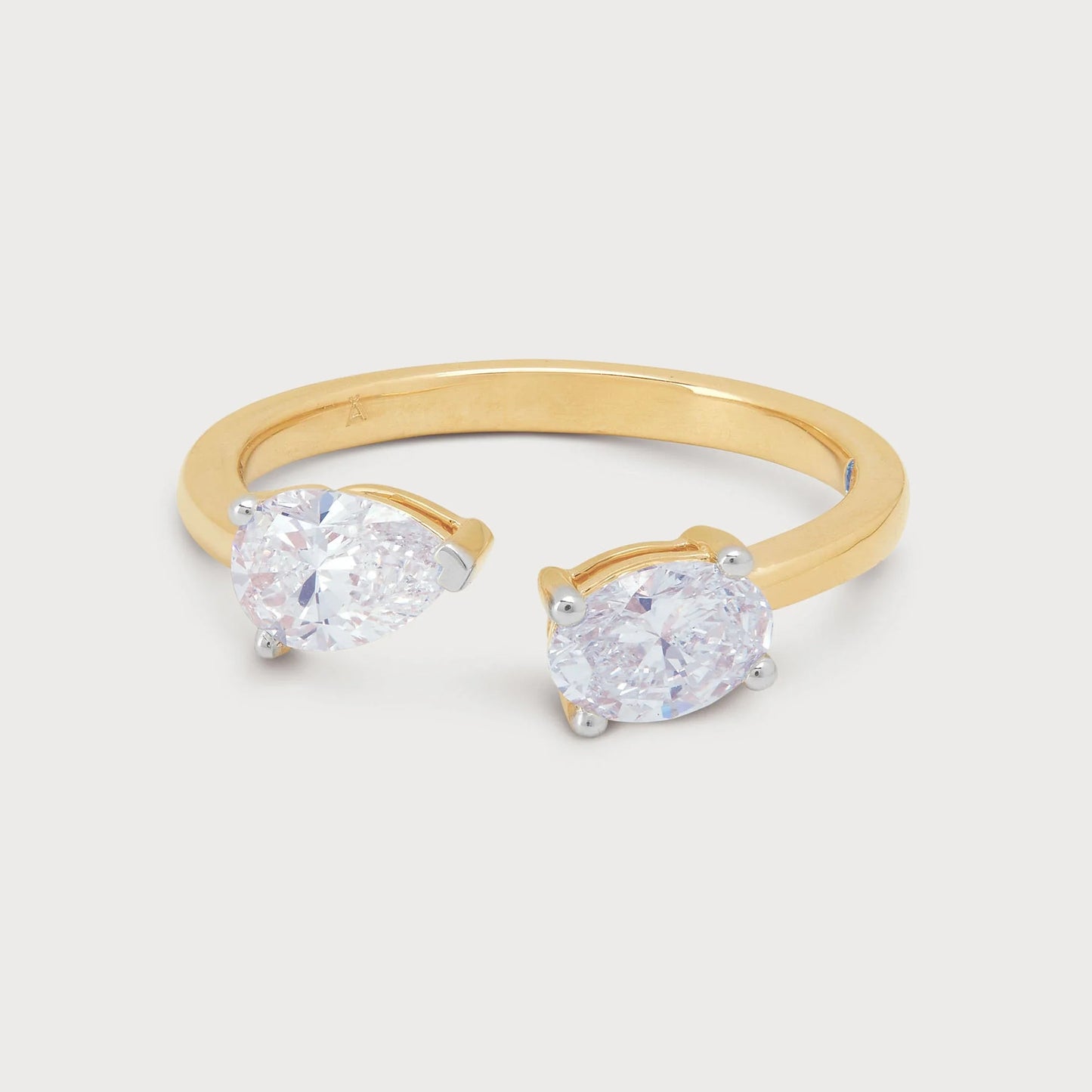 The Twin Pear Ring: A stunning open gold band ring featuring two brilliant pear-shaped diamonds. Perfect for fine jewelry collections.