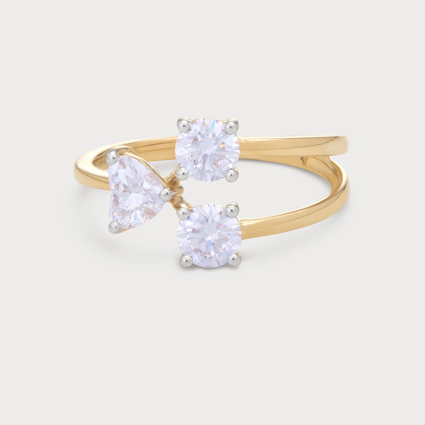 The Amara Ring - A modern bypass yellow gold ring featuring three sparkling diamonds: two round brilliant cut and one pear-shaped, perfect for engagements or a statement piece of diamond jewelry.