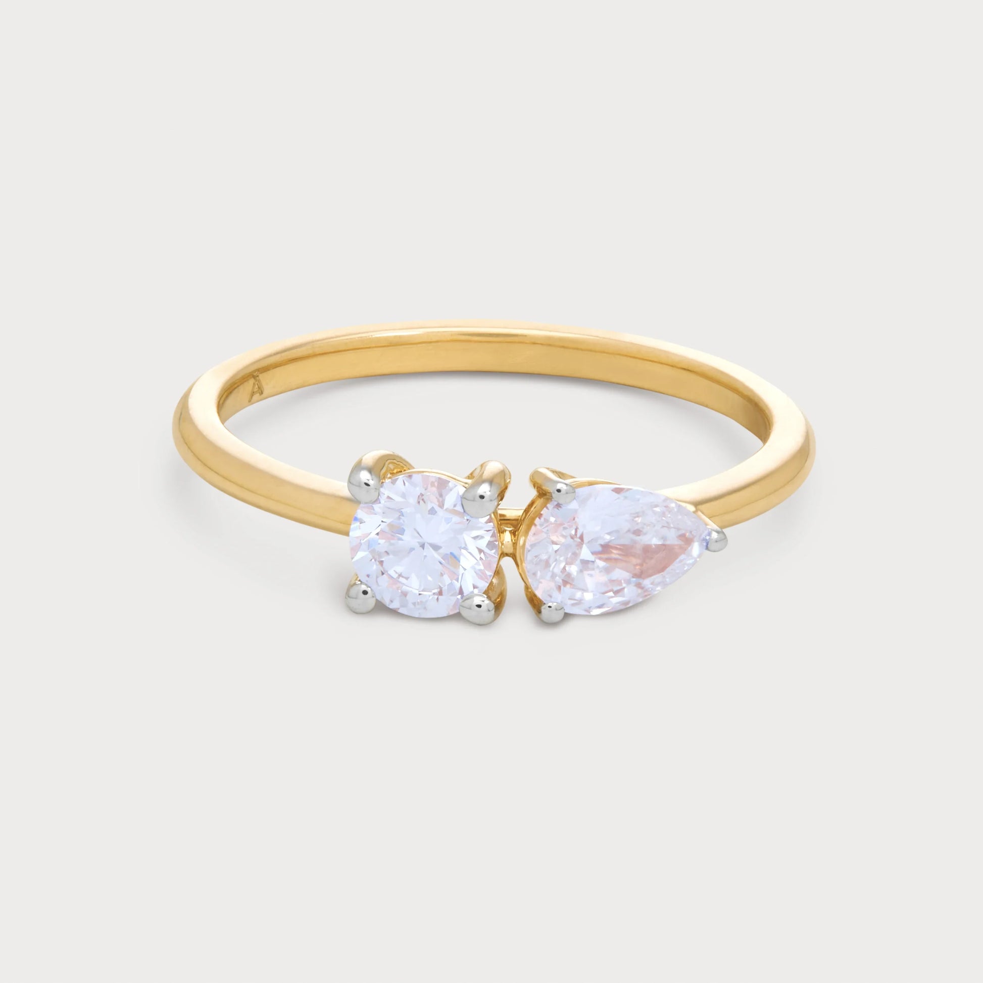 The Fleur Sol Ring, a gold diamond ring featuring a round brilliant and a pear-cut diamond, perfect for engagement or a unique fine jewelry gift.