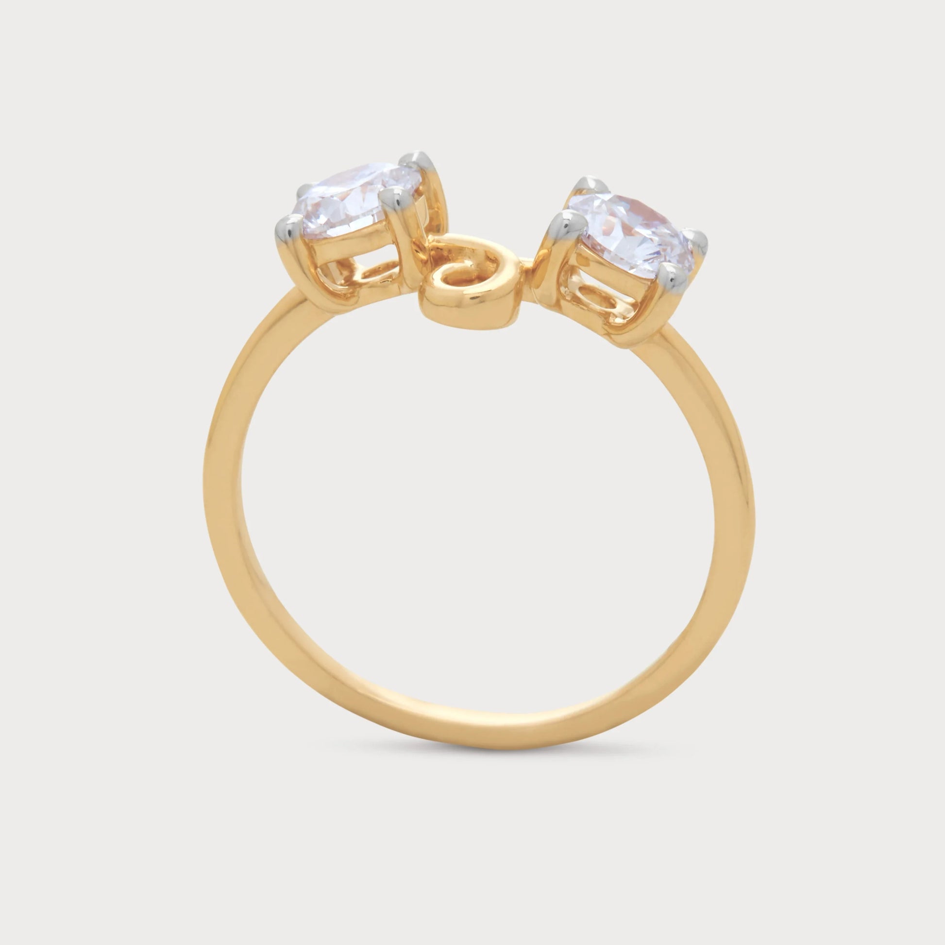 The Caia Ring, an elegant gold ring featuring two round-cut diamonds with a unique intertwined design, ideal for diamond jewelry.