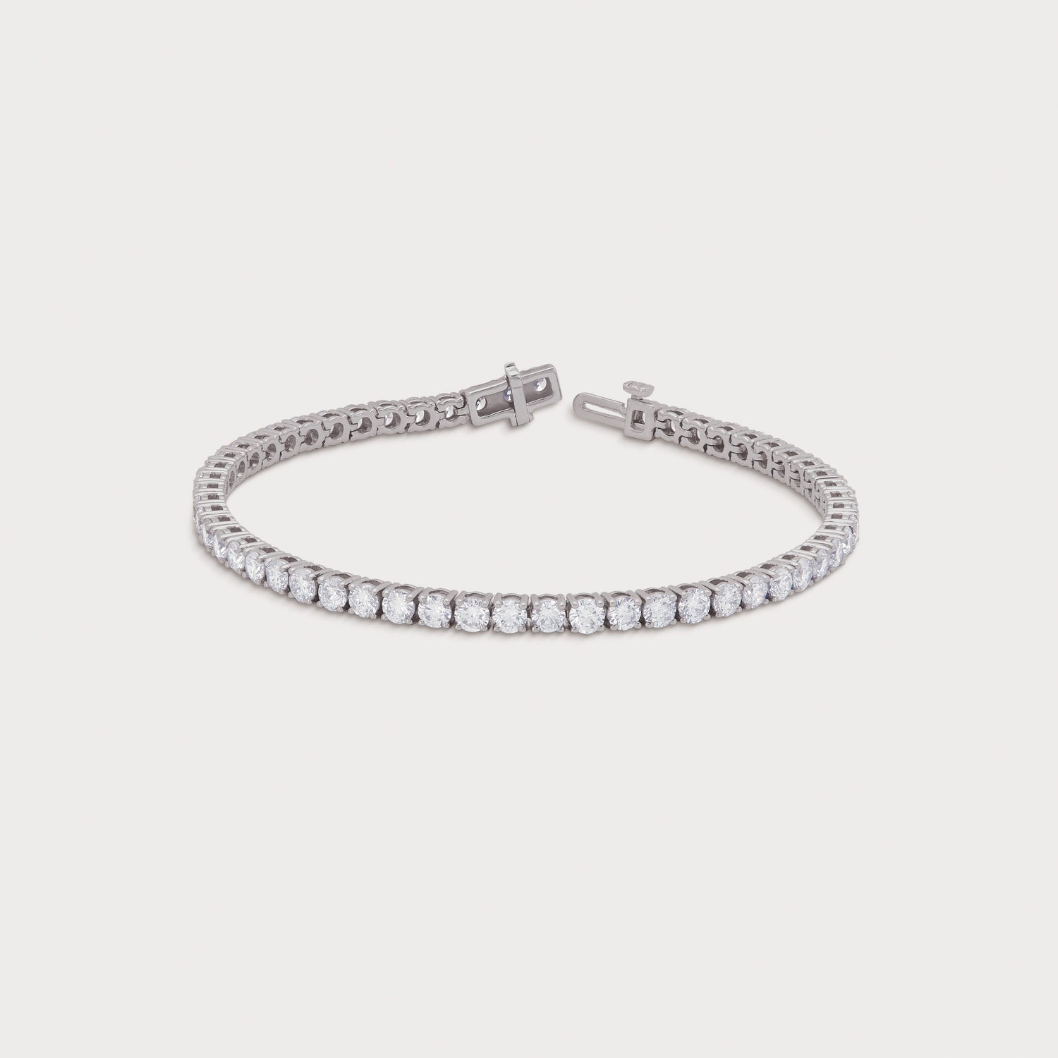 White gold tennis bracelet featuring a continuous line of sparkling round diamonds with an open clasp, perfect for elegant diamond jewelry collections.