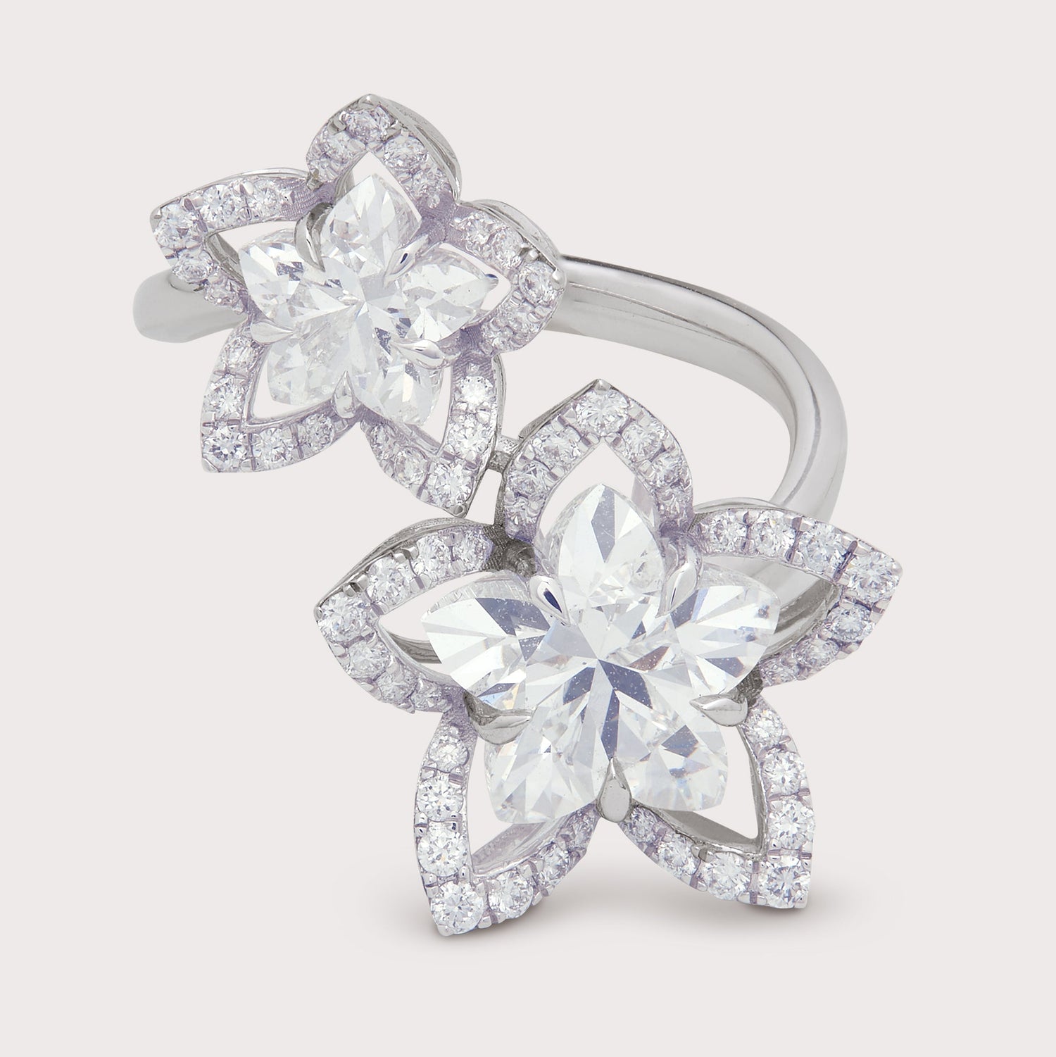 White gold or platinum diamond flower ring featuring two large marquise cut diamonds surrounded by pavé set round brilliant diamonds in a floral design. Diamond cluster ring for women, fine jewelry.