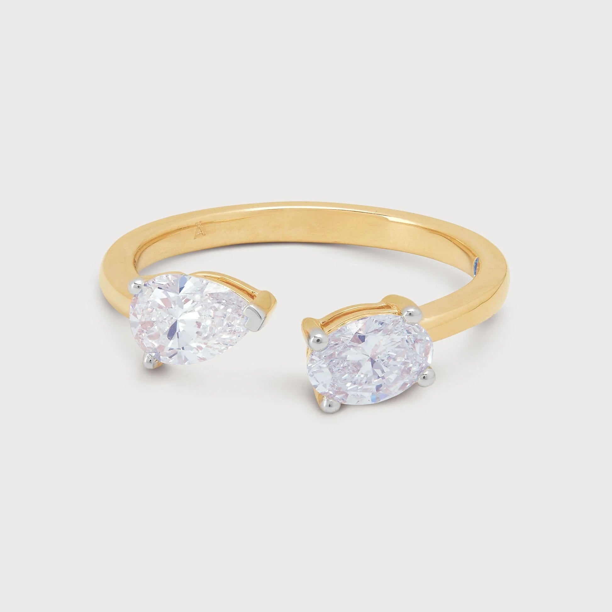 The Twin Pear Ring: A stunning open gold band ring featuring two brilliant pear-shaped diamonds. Perfect for fine jewelry collections.