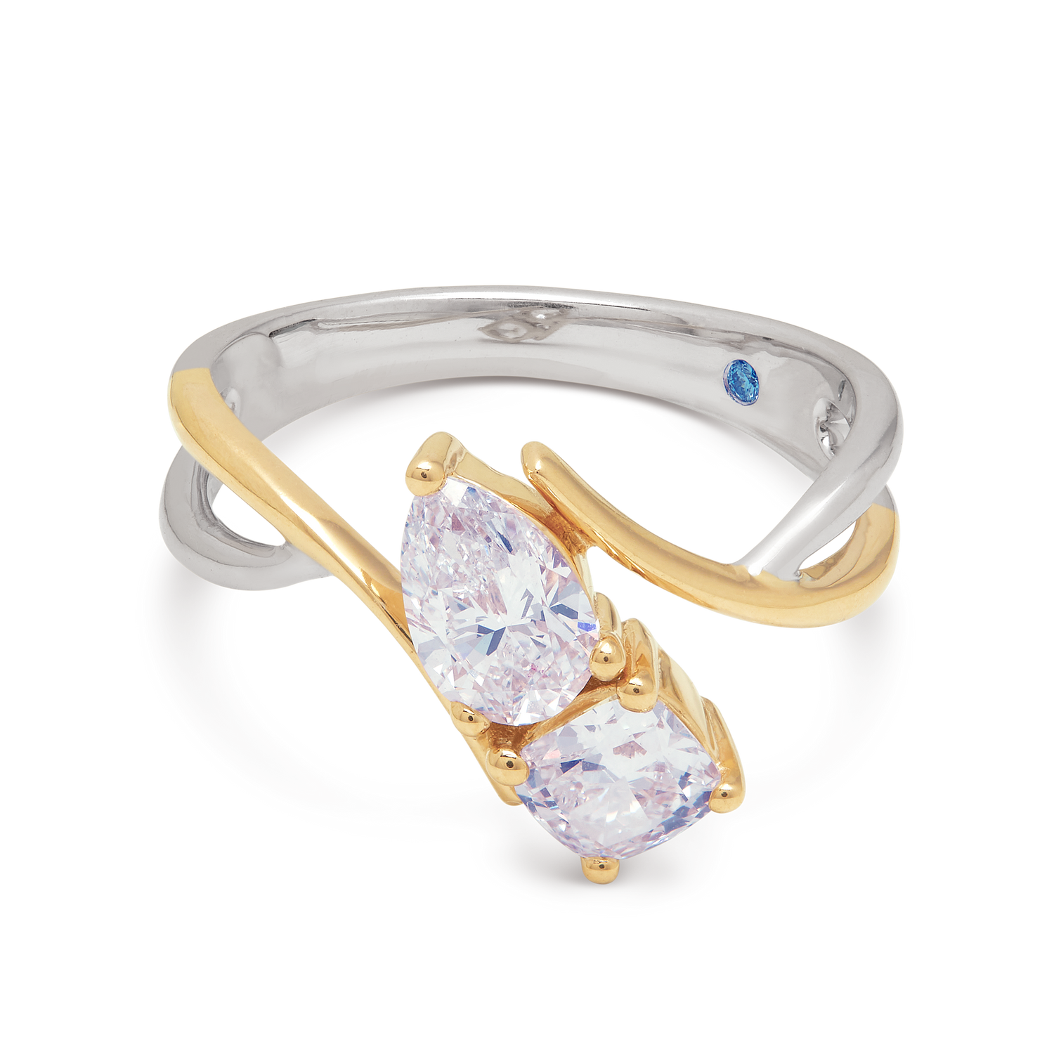 The Izar Ring: Two-tone diamond ring with intertwined yellow gold and white gold bands, featuring two pear-shaped diamonds and a blue gemstone. Shop luxury diamond jewelry.