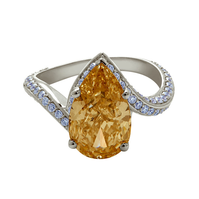 The Champagne Wave Pear Ring, featuring a pear-shaped champagne diamond set in a white gold wave band adorned with brilliant blue accent diamonds. Ideal for fine jewelry and engagement.