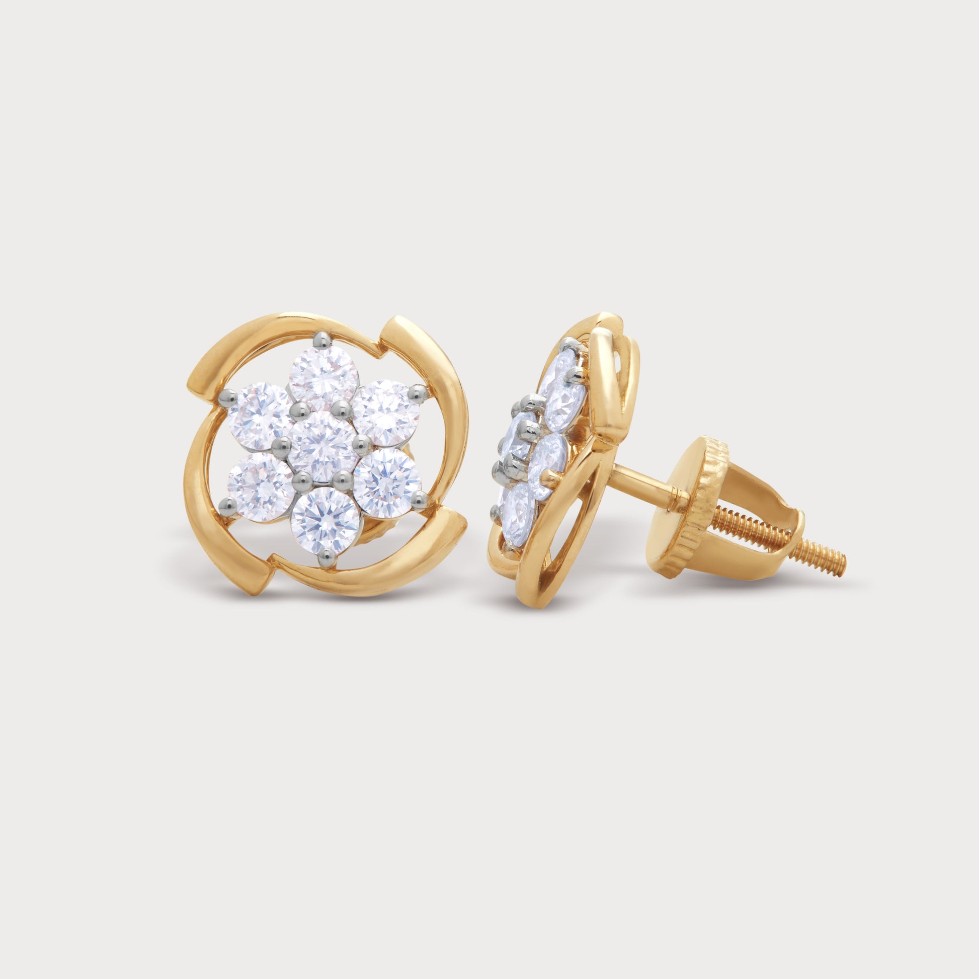 The Chakra Flower Studs: A pair of elegant yellow gold stud earrings featuring a flower cluster of sparkling round diamonds with a unique swirling gold setting and secure screw-back posts.