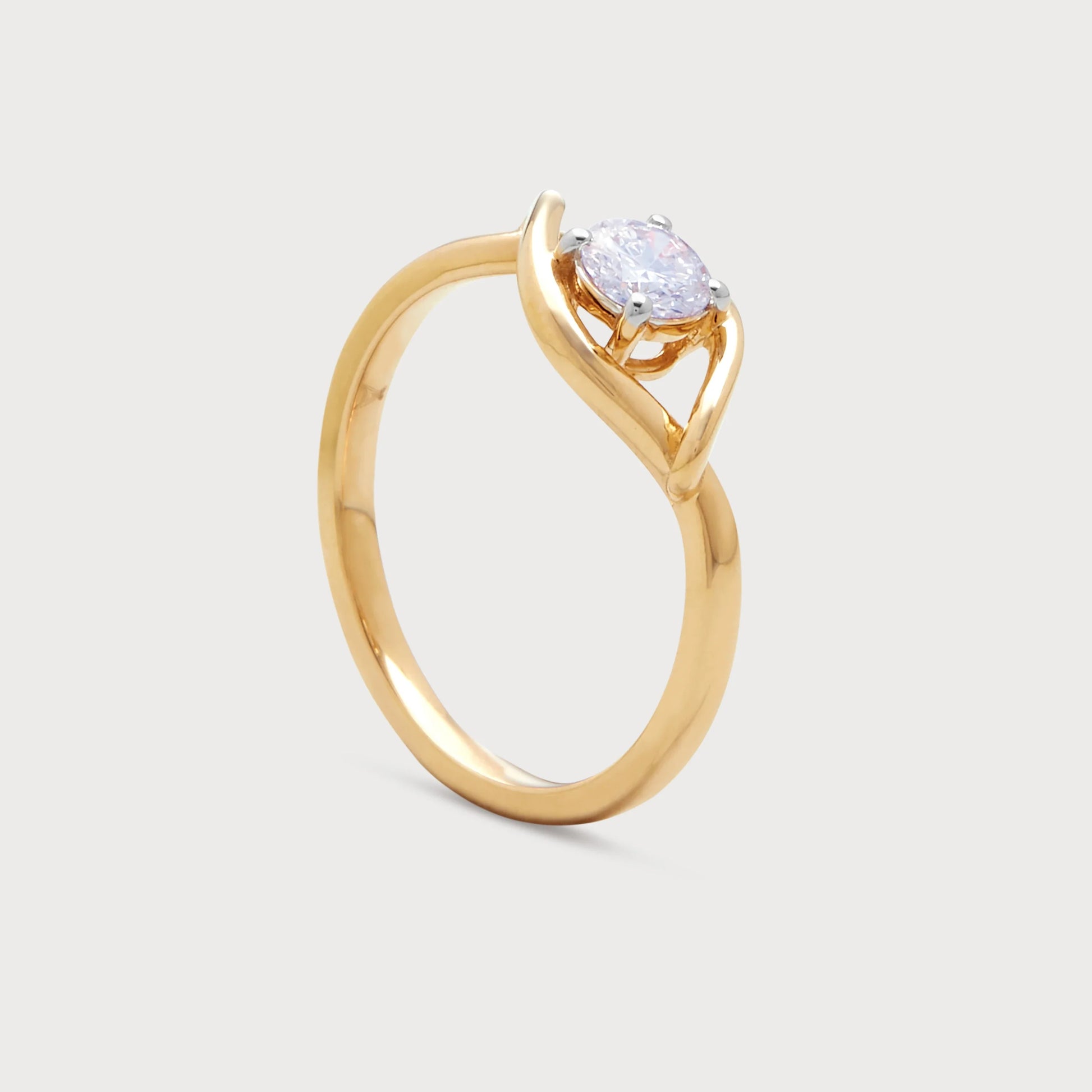 The Enso Ring: Gold solitaire diamond engagement ring with a unique bypass band design.