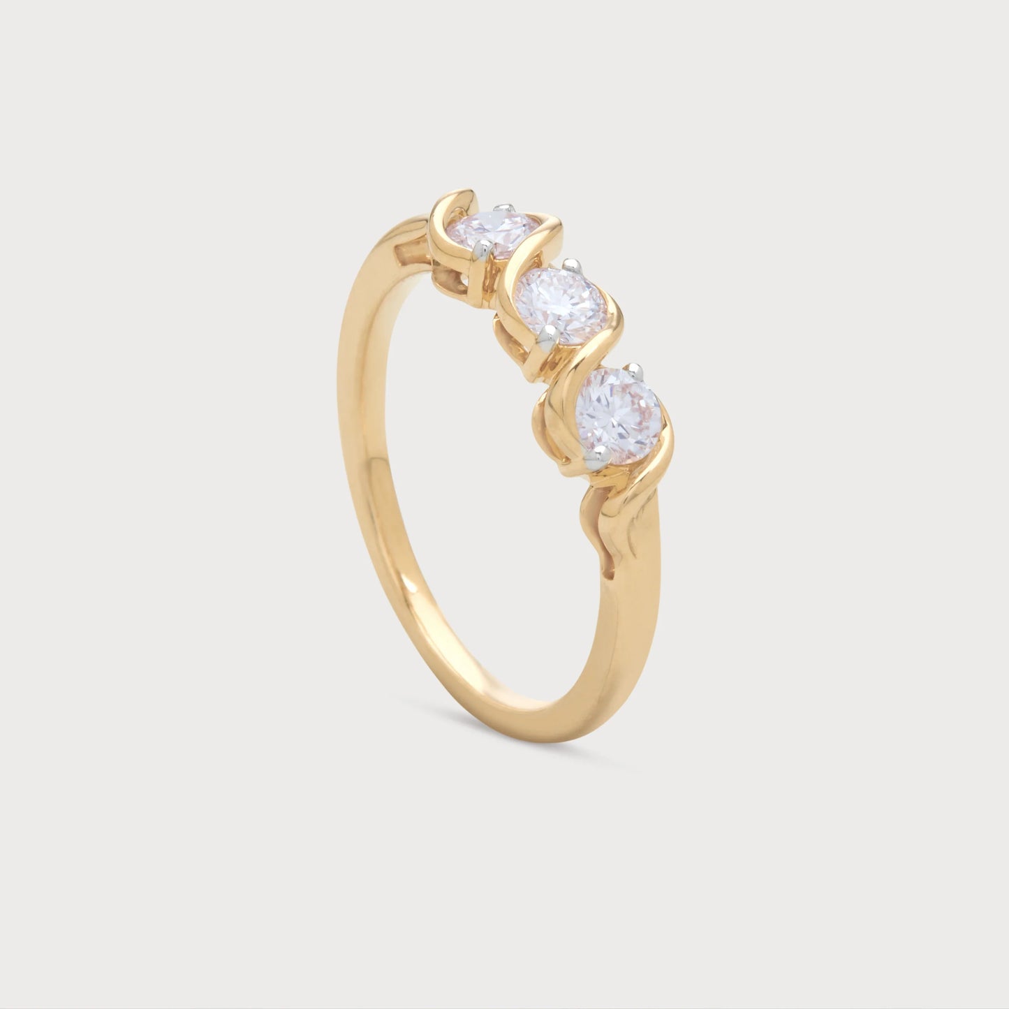 The Selene Ring: elegant yellow gold three-stone diamond ring with a distinctive wave-inspired setting, perfect for women's anniversary or special occasion jewelry.