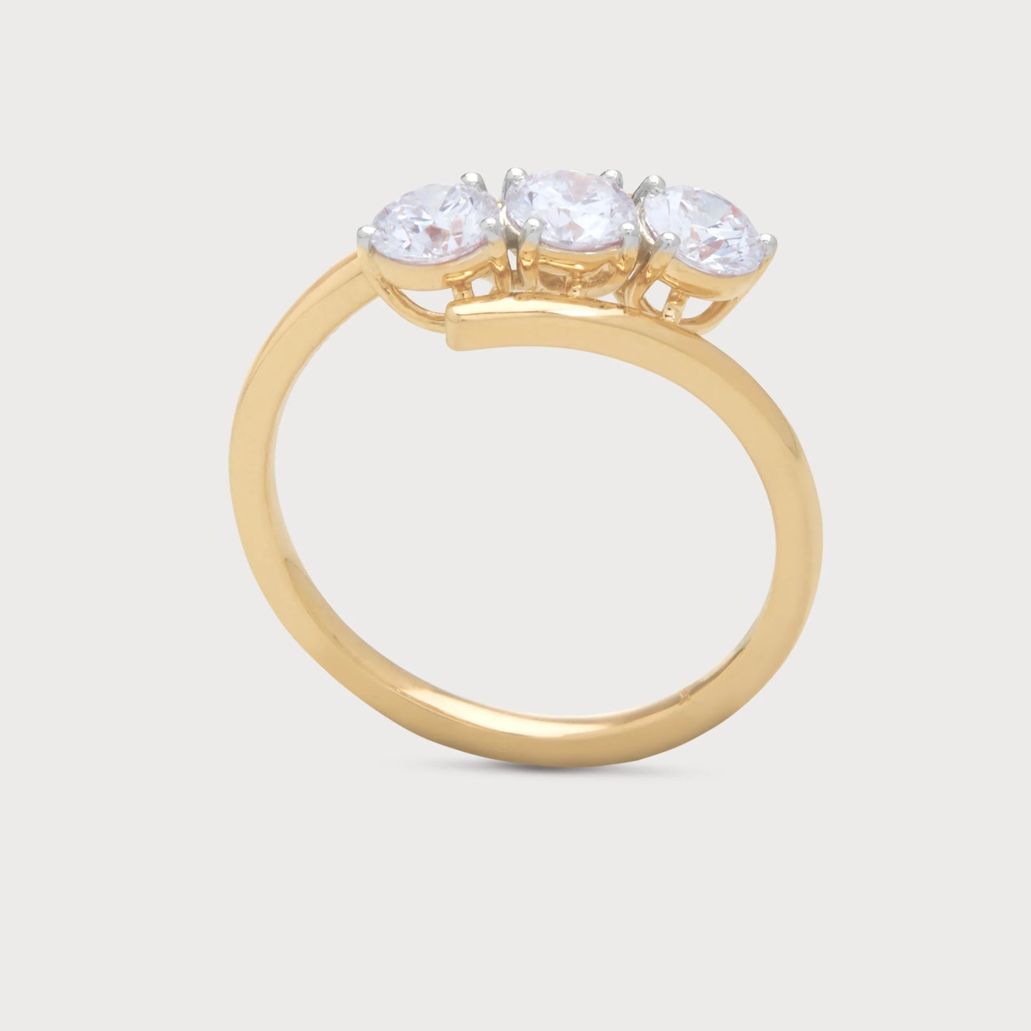 The Selara Ring, a gold bypass ring featuring three brilliant round diamond stones. Elegant diamond jewelry for women.