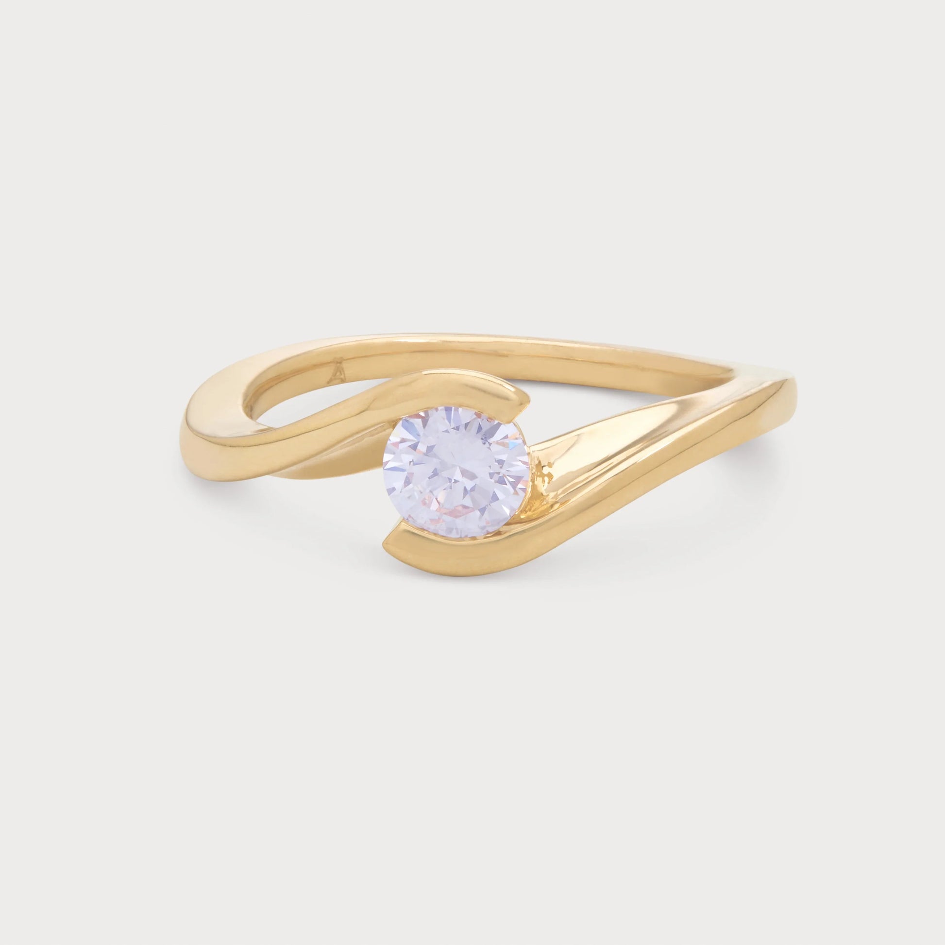 The Enfold Ring, a modern yellow gold bypass diamond ring with a brilliant round cut diamond, ideal for engagement or as a statement piece of fine jewelry.