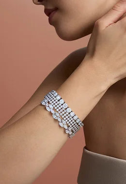 Silver bracelet on a wrist with a neutral background