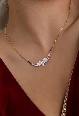 A close-up of a model wearing a delicate gold chain necklace with a butterfly-shaped pendant. The pendant features clear gemstones set in silver-toned metal, with small black beads spaced along the chain.